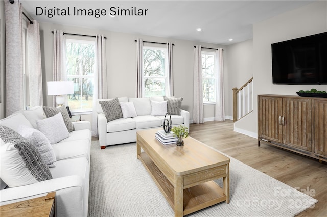 living room with plenty of natural light and light hardwood / wood-style flooring