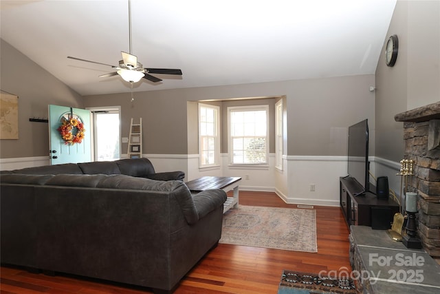 living room with ceiling fan, dark hardwood / wood-style floors, and vaulted ceiling