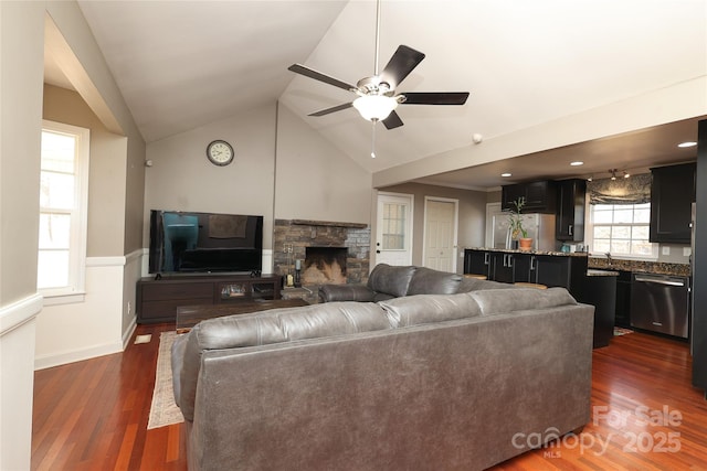 living room with vaulted ceiling, ceiling fan, dark hardwood / wood-style flooring, and a fireplace