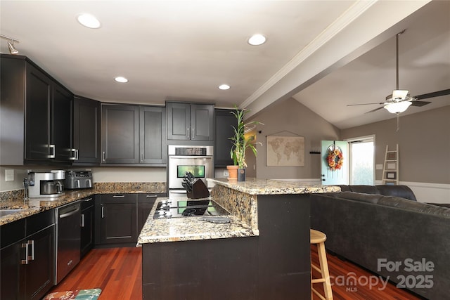 kitchen with a kitchen breakfast bar, light stone countertops, a center island, and appliances with stainless steel finishes