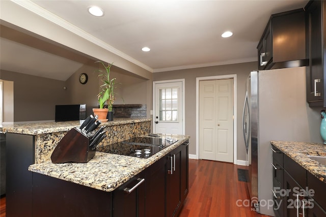 kitchen featuring light stone counters, black electric stovetop, and crown molding