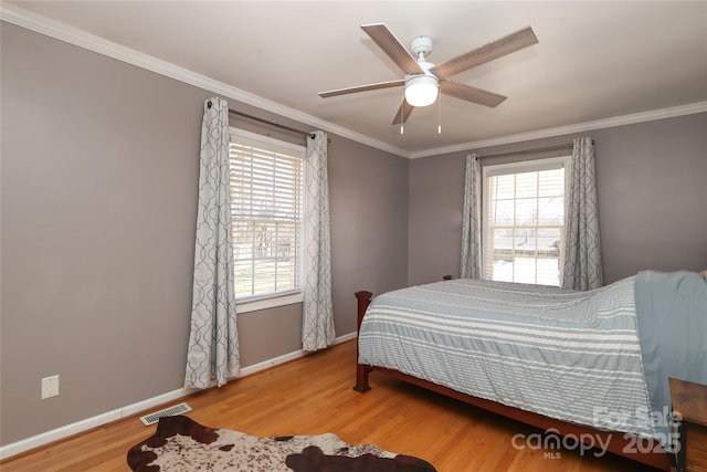 bedroom featuring hardwood / wood-style flooring, ceiling fan, and ornamental molding