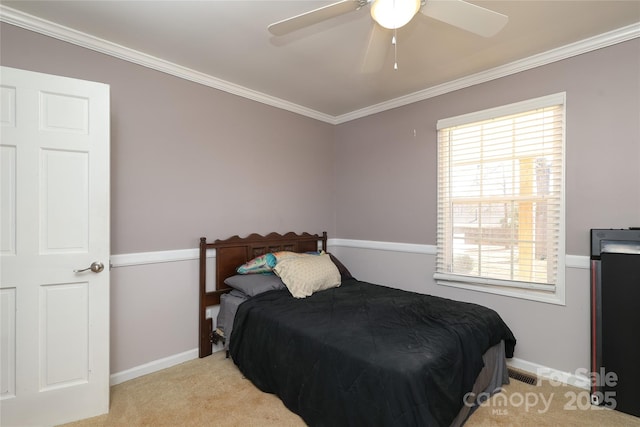 bedroom featuring ornamental molding, light colored carpet, and ceiling fan