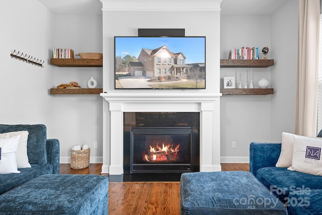 sitting room featuring ornamental molding and dark wood-type flooring