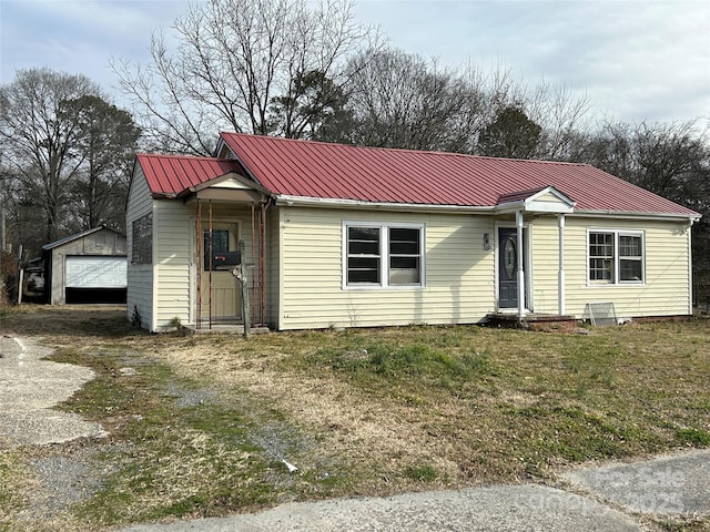 view of front of home featuring a garage, an outdoor structure, and a front lawn