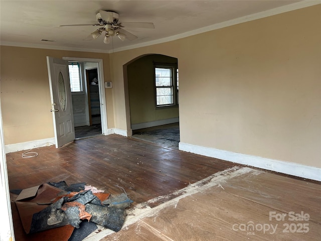 unfurnished room with crown molding, dark wood-type flooring, and ceiling fan