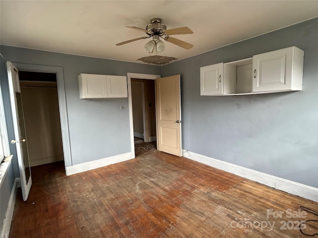 unfurnished bedroom with dark wood-type flooring, a closet, and ceiling fan