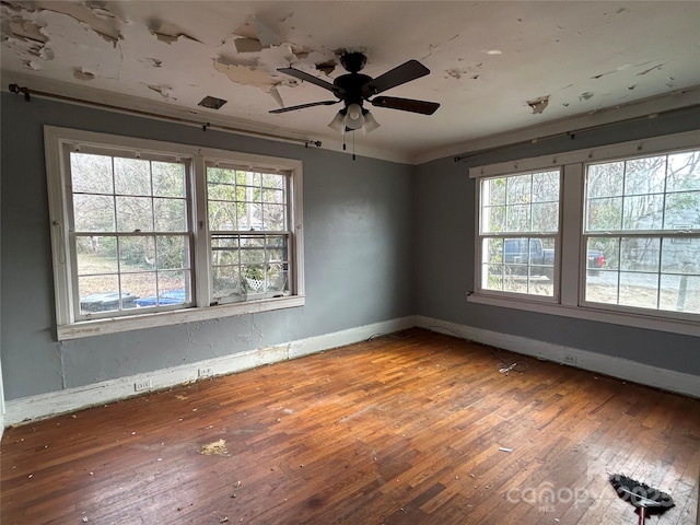 spare room featuring hardwood / wood-style floors, crown molding, a healthy amount of sunlight, and ceiling fan