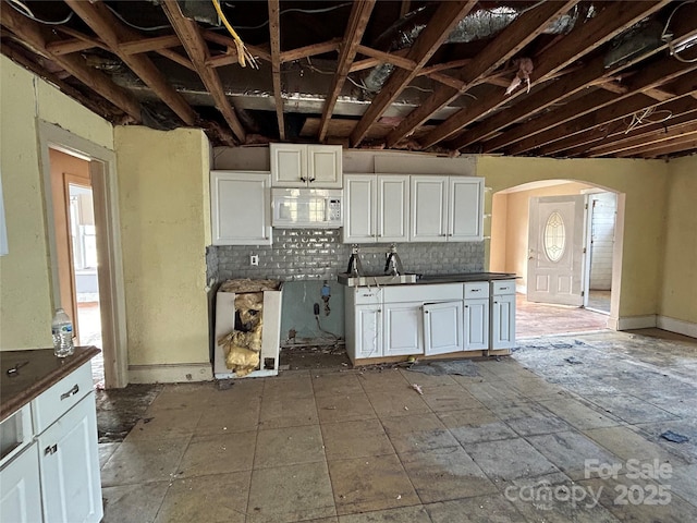 kitchen featuring tasteful backsplash and white cabinets