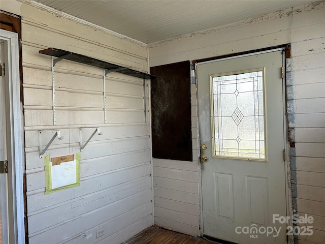 entryway featuring hardwood / wood-style flooring and wooden walls