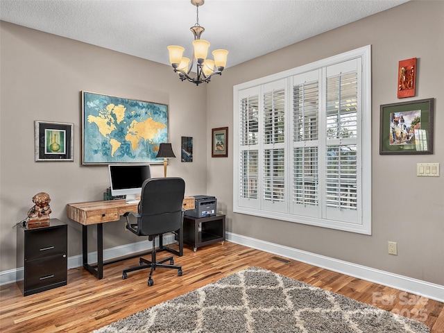 office area featuring a textured ceiling, light hardwood / wood-style flooring, and a chandelier