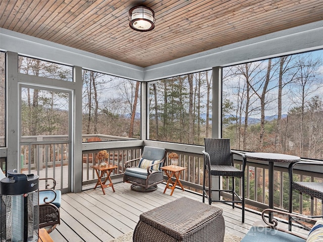 sunroom / solarium featuring wood ceiling and plenty of natural light