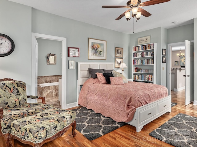 bedroom featuring ceiling fan with notable chandelier and light wood-type flooring