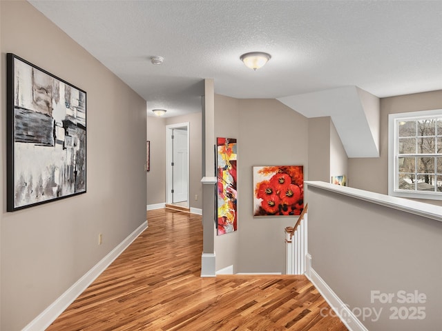 hallway featuring light hardwood / wood-style flooring and a textured ceiling