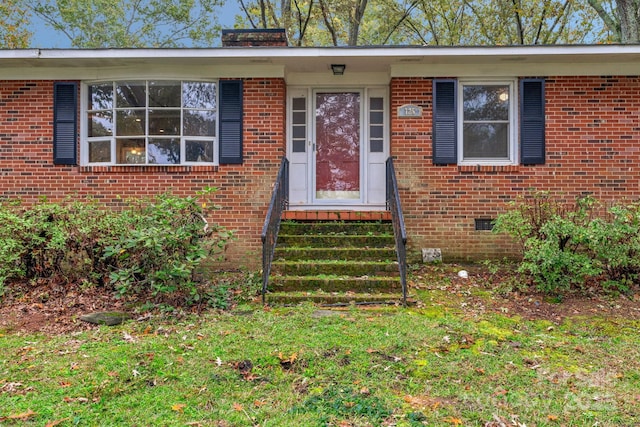 view of exterior entry featuring crawl space and brick siding