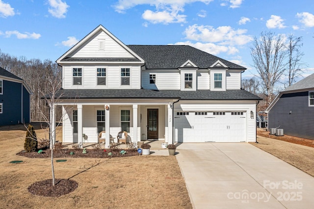 view of front of property featuring a porch, a garage, a front yard, and cooling unit