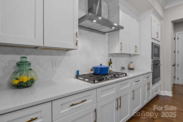 kitchen with built in microwave, stainless steel gas cooktop, white cabinetry, light stone countertops, and range hood