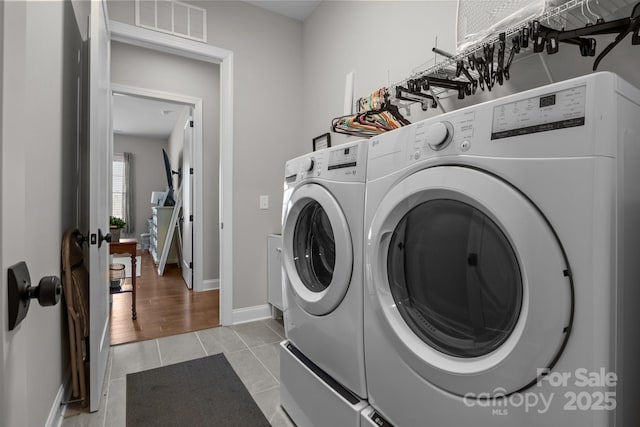 laundry room featuring light tile patterned floors and washer and dryer