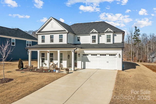 view of front of home with a garage, a front yard, and covered porch