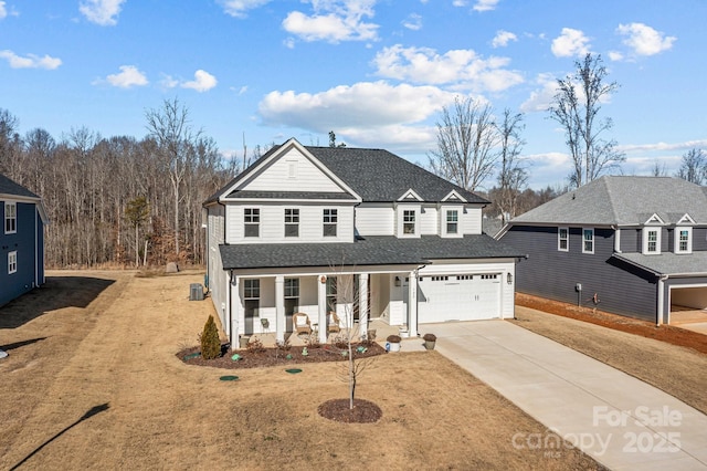 view of front of home with a porch, a garage, cooling unit, and a front lawn