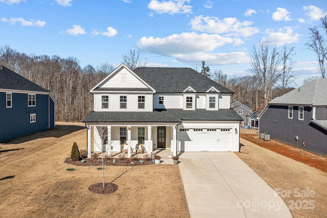 front facade with a porch, a garage, and a front yard