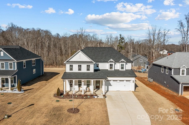 view of property featuring a garage, a front yard, and covered porch