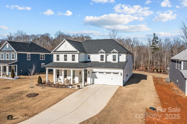 view of property with a garage, a front yard, covered porch, and central air condition unit