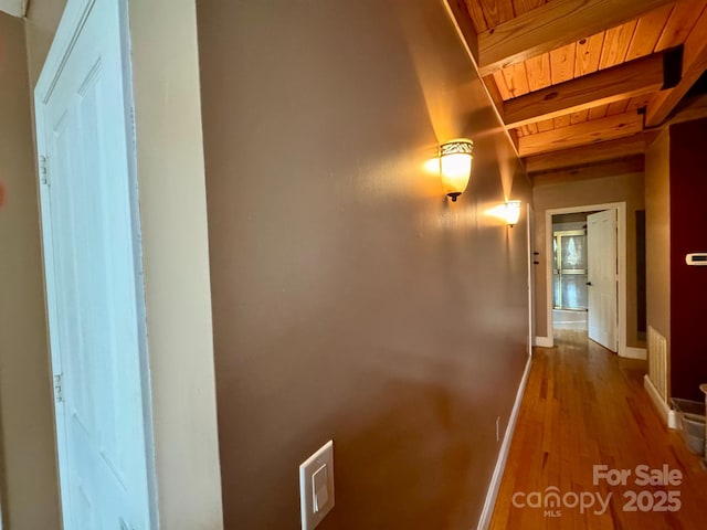 hall with hardwood / wood-style flooring, wooden ceiling, and beam ceiling