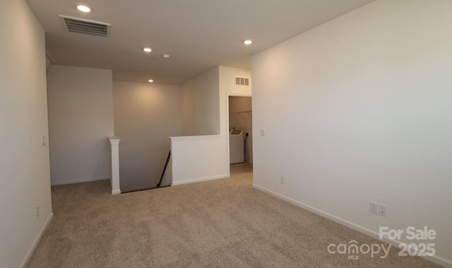 carpeted spare room featuring washer / clothes dryer