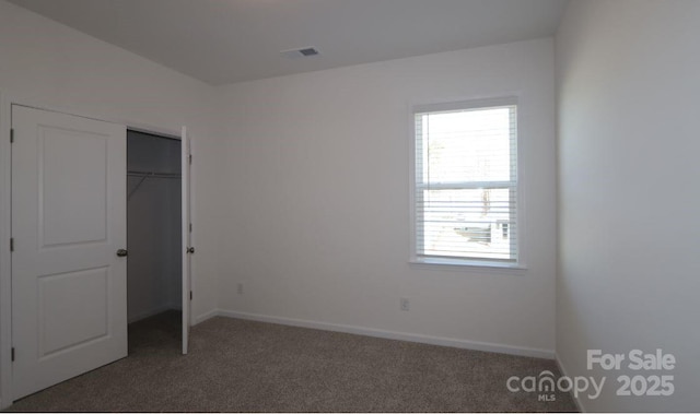 unfurnished bedroom featuring dark carpet and a closet