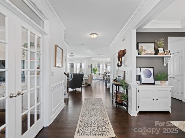 entrance foyer featuring dark wood-type flooring, ornamental molding, and french doors