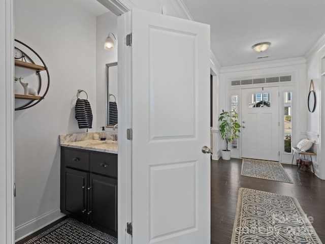 bathroom with ornamental molding, hardwood / wood-style floors, and vanity