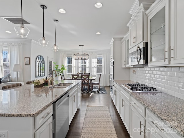 kitchen with white cabinetry, sink, hanging light fixtures, a kitchen island with sink, and stainless steel appliances