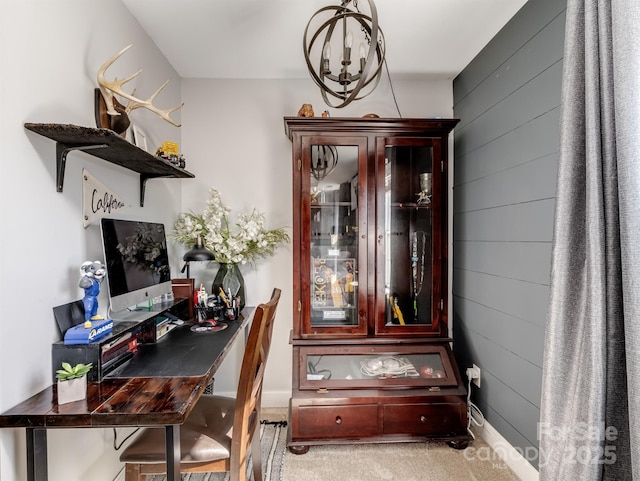 home office featuring light carpet, a notable chandelier, and wood walls