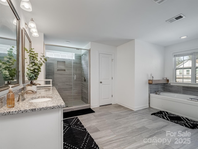 bathroom featuring shower with separate bathtub and vanity