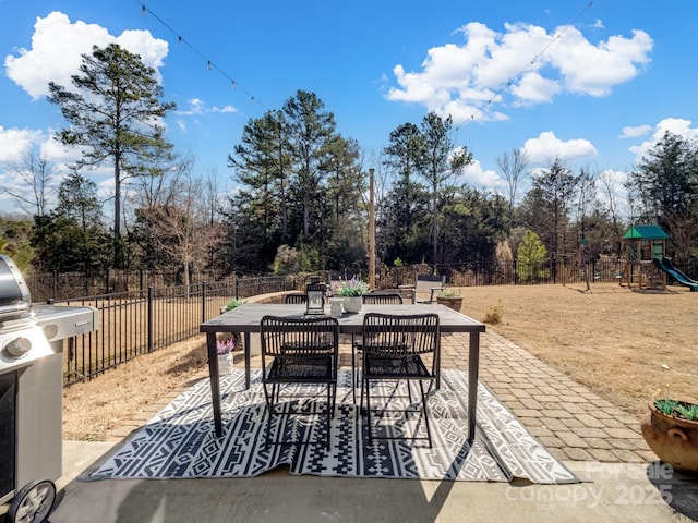 view of patio with grilling area and a playground