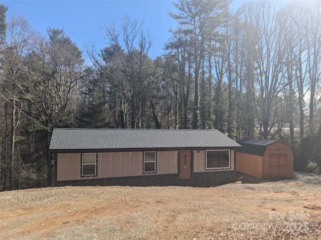 single story home with a storage shed