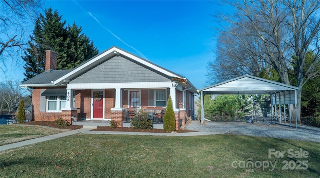 view of front of house featuring a carport, a front yard, and covered porch