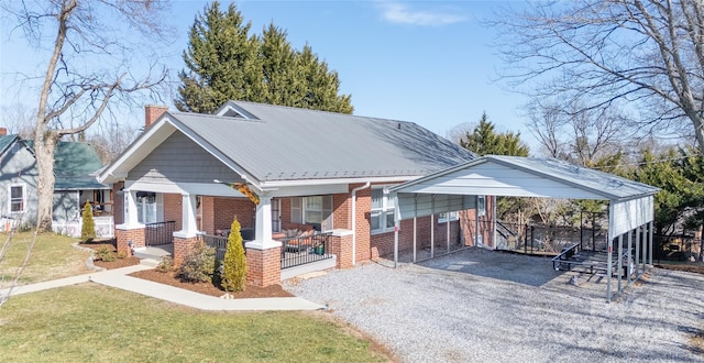 view of front of property with a front yard, a carport, and a porch