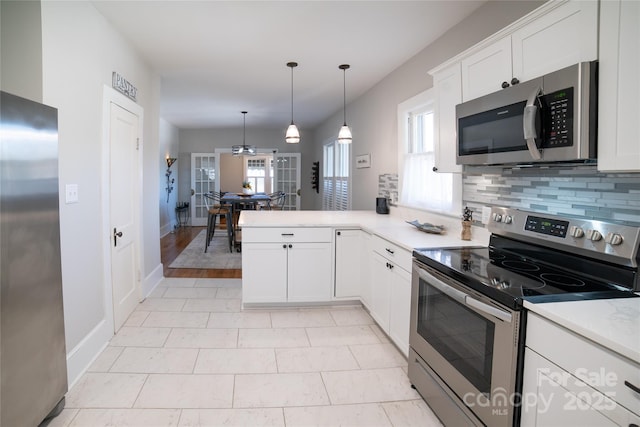 kitchen featuring white cabinetry, tasteful backsplash, hanging light fixtures, kitchen peninsula, and stainless steel appliances