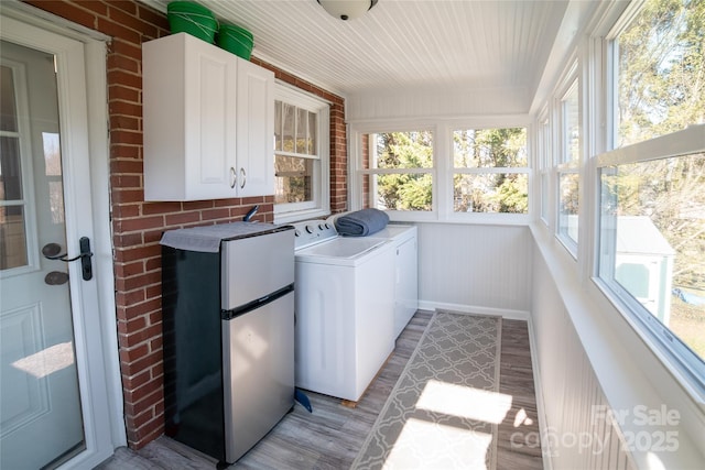 laundry area featuring cabinets, washer and dryer, and light wood-type flooring