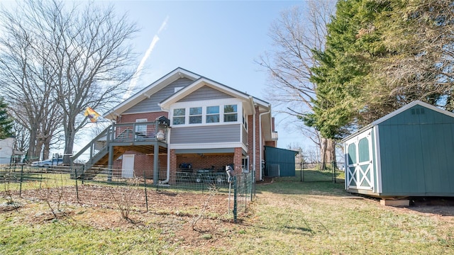 back of house featuring a wooden deck, a yard, and a shed