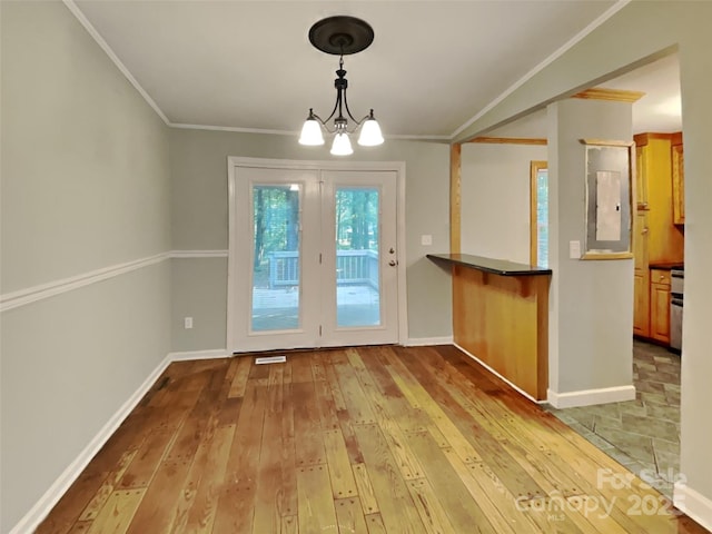 entryway with a notable chandelier, crown molding, electric panel, and light hardwood / wood-style flooring