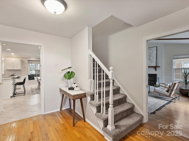 staircase with hardwood / wood-style flooring and a fireplace