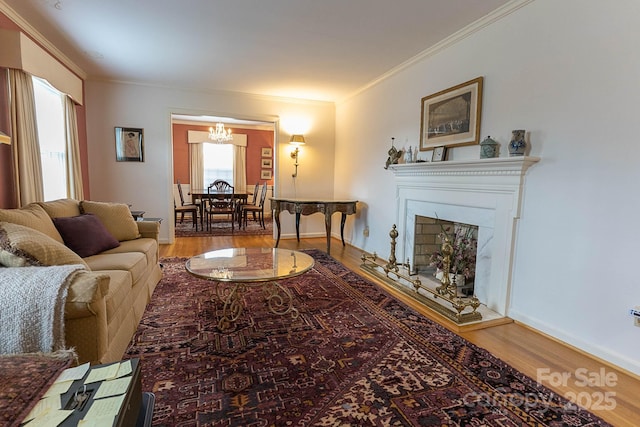 living room featuring an inviting chandelier, hardwood / wood-style floors, and crown molding