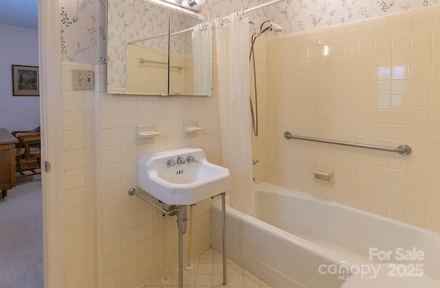 bathroom featuring sink, tile walls, and shower / bath combo with shower curtain