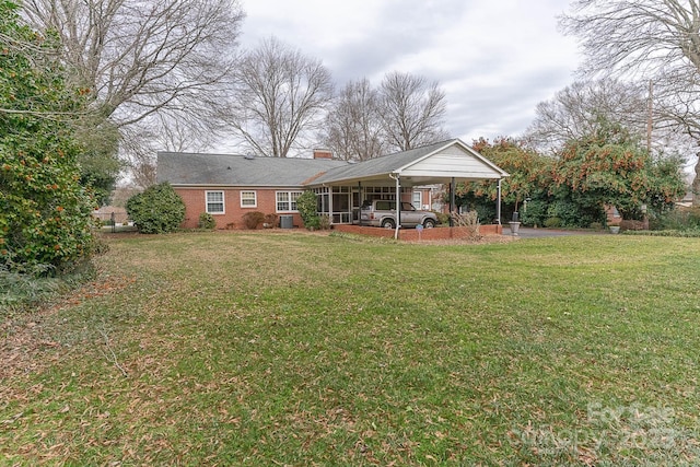 rear view of property featuring a carport and a lawn