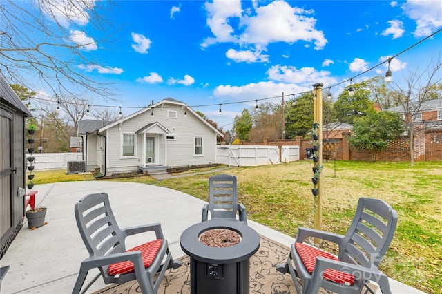 exterior space with central air condition unit, a lawn, a fire pit, a swimming pool, and a patio