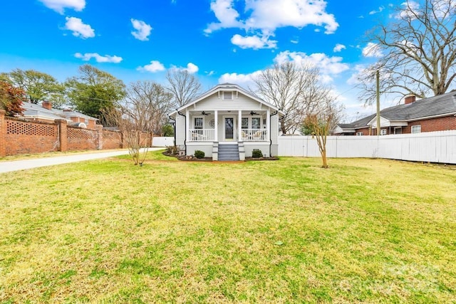 back of house with covered porch and a lawn