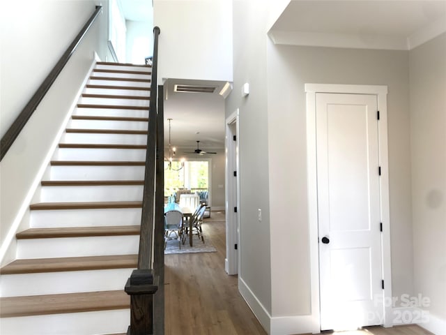 staircase with baseboards, visible vents, and wood finished floors